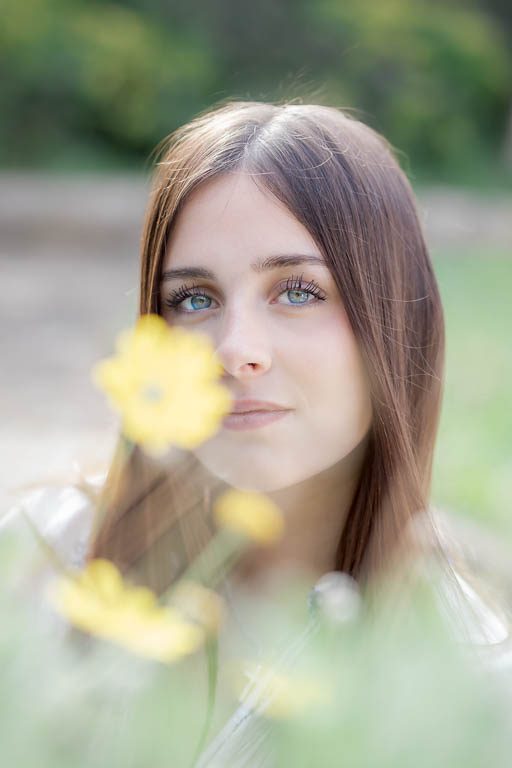 Portrait photo Luana en extérieur dans les champs au printemps fleur - focus sur ses yeux bleus
